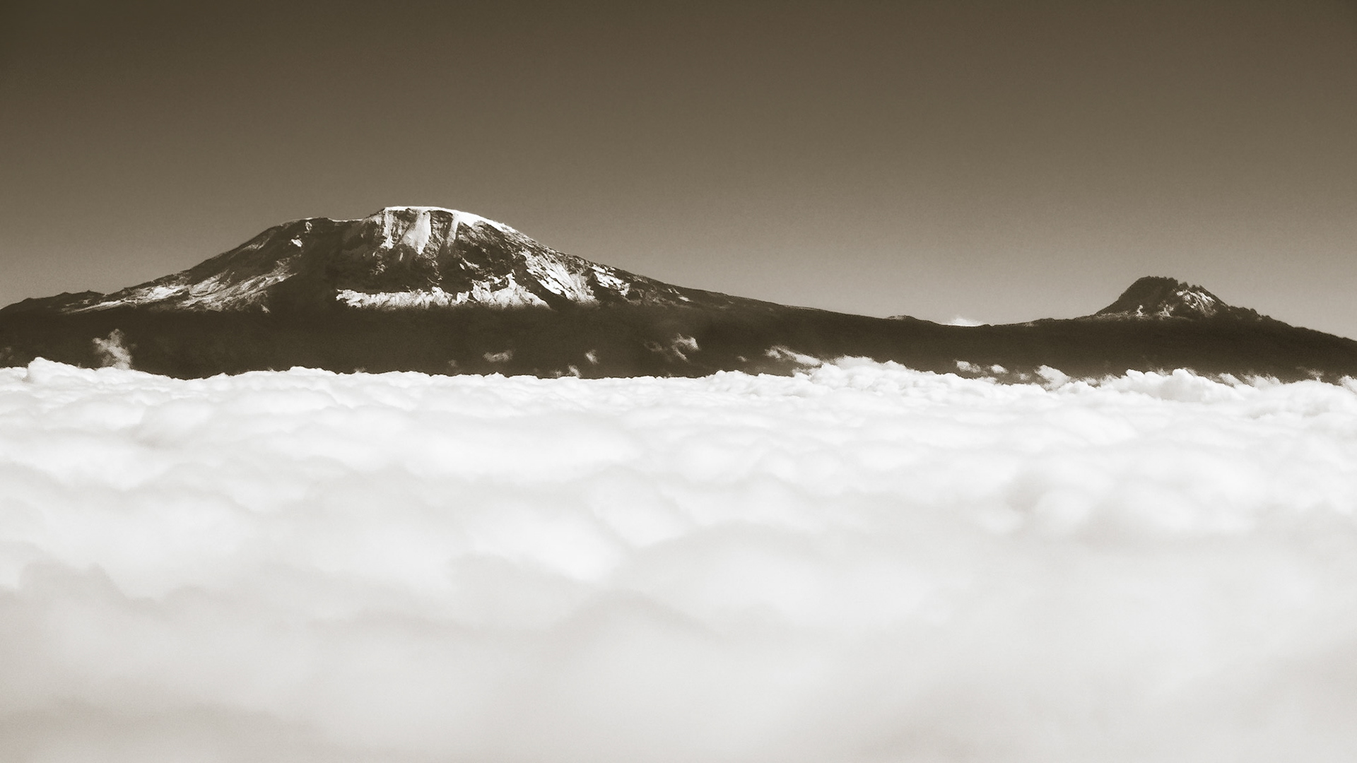 The peaks of volcanic Mount Kilimanjaro, Africa's tallest mountain, float above the clouds on the plains below