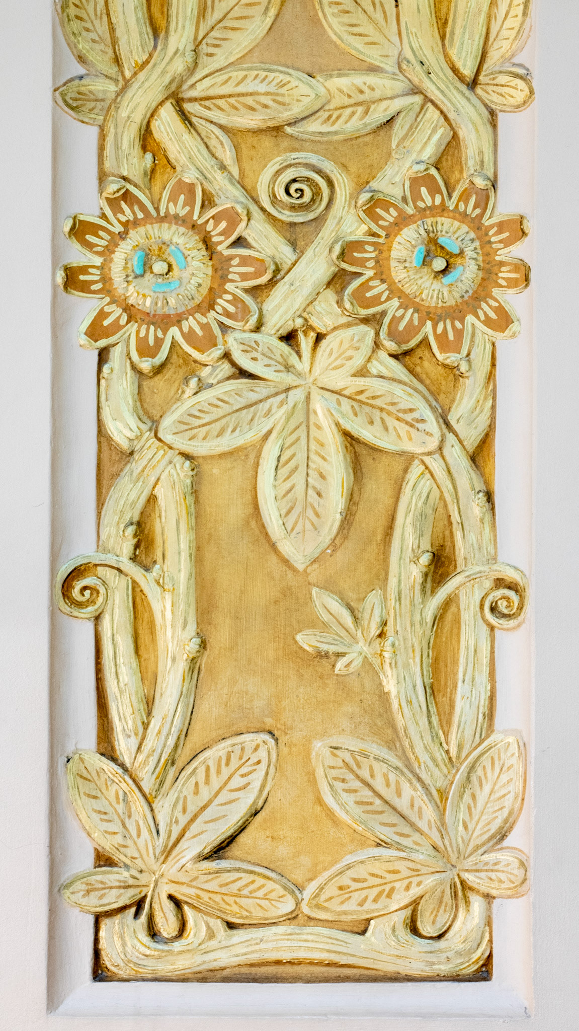 Bright yellow sculptures of sunflowes with faces plus leaves, and stems in Galeries Lafayette, Paris