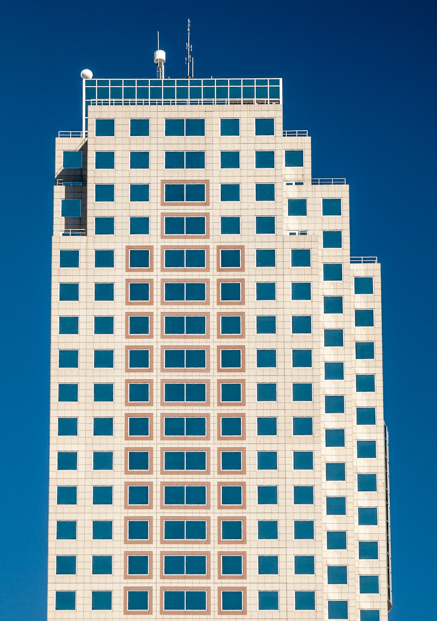 Blue sky reflected in multiple square windows of a multi-storey building in The Exchange District, Winnipeg, Manitoba, Canada
