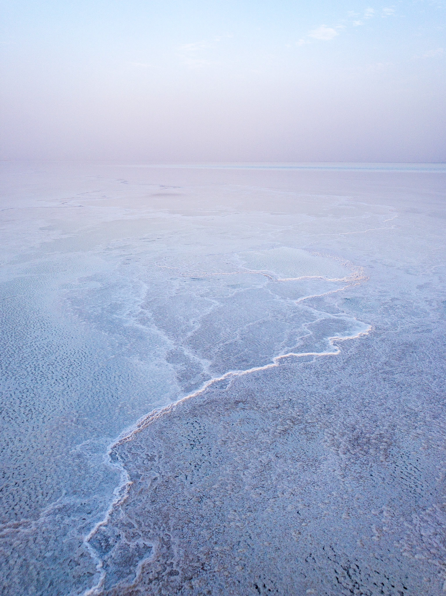 A white ridge of salt snakes its way across the blue waters of Lake Asale in Ethiopia's hot and dry Danakil Depression, the most inhospitable place on Earth.