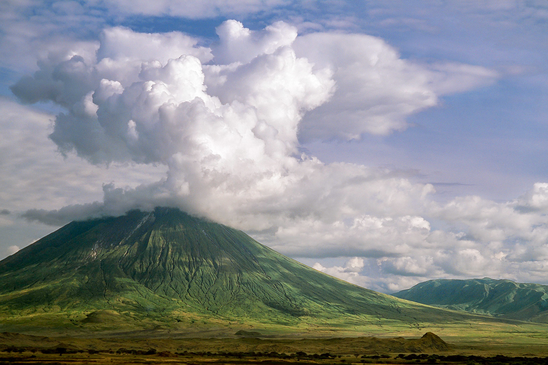 Valocanic Ol Doinyo Lengai, regarded by the Maasai as the Mountain of God, stands high above the flat valley floor and western wall of the Great Rift Valley, tanzania, East Africa