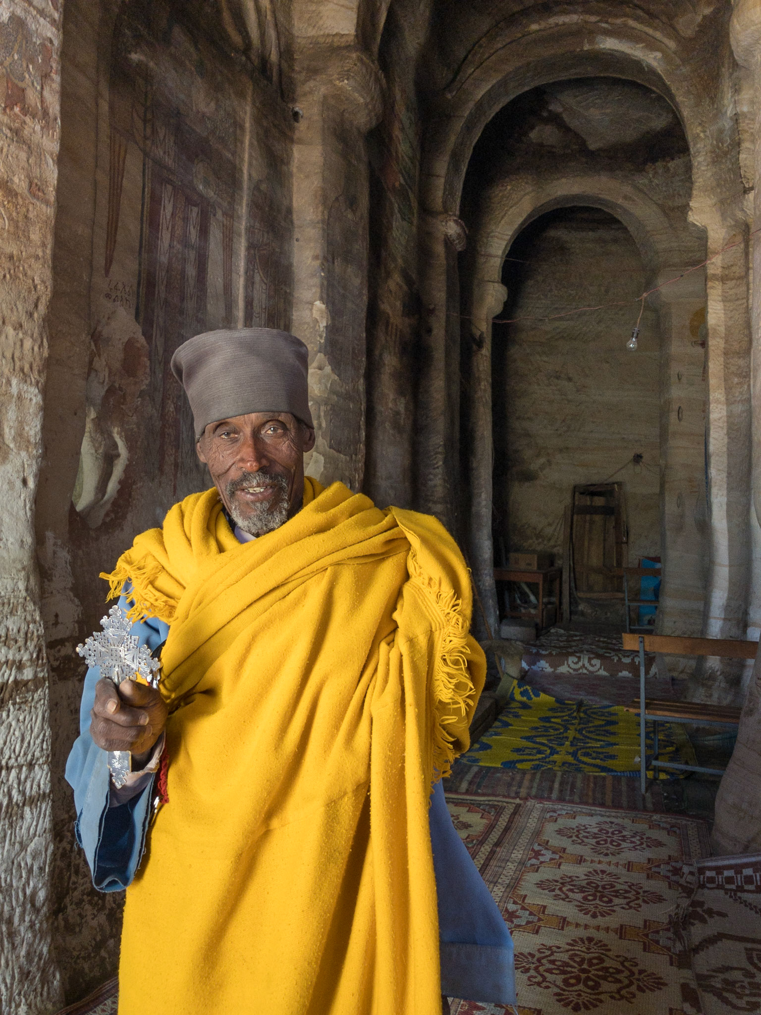 A priest holds a cross inside the rock-hewn church of Maryam Korkor, Gher'Alta, Tigray, Ethiopia