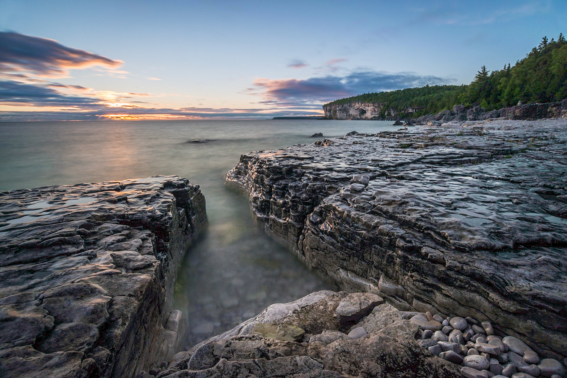 A rocky, limestone inlet at sunrise along the Georgian Bay shore of Bruce Peninsula National Park at Storm Haven, one of the core wilderness areas of Ontario's Niagara Escarpment, A UNESCO World Biosphere Reserve.
