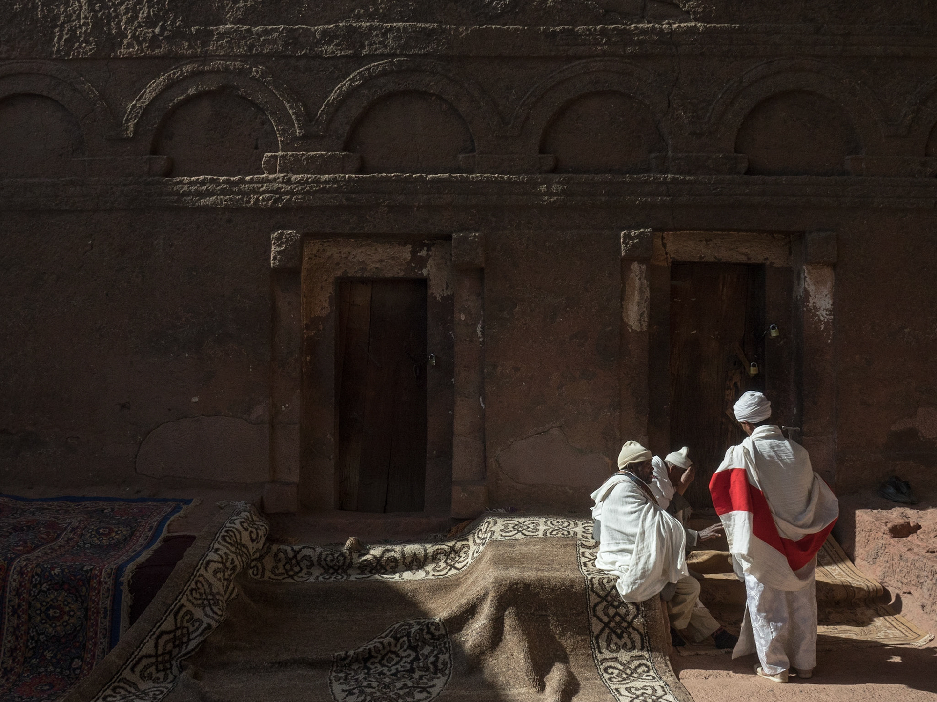 Priest and monks are in discussion outside Biete Maryam, Lalibela, Ethiopia