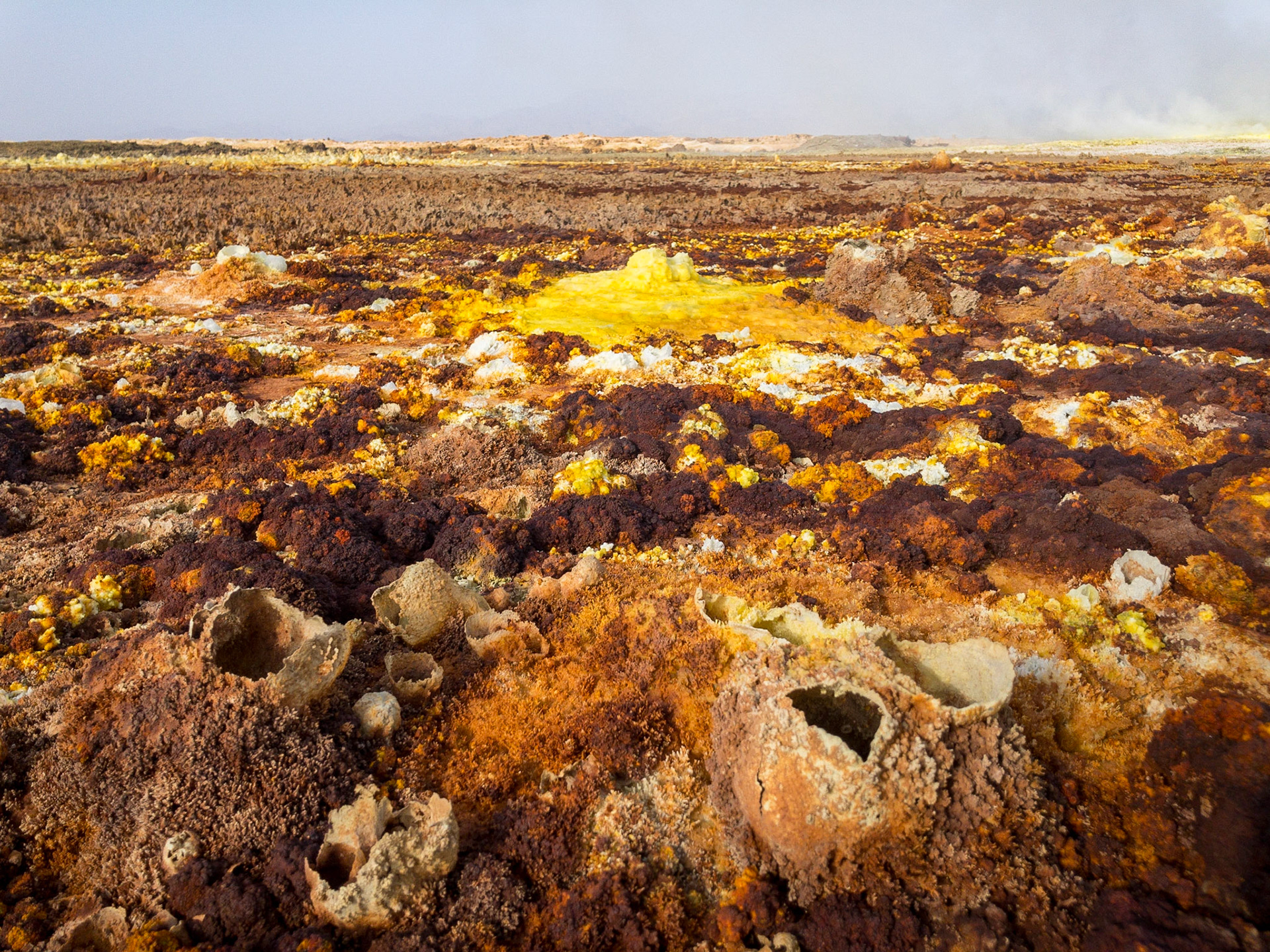 Fumaroles spouting sulphuric acid and gas erupt on the floor of Dallol in Ethiopia’s Danakil Depression, creating yellow and green pools and orange-brown geometric patterns, in the hottest, driest, most inhospitable place on Earth.