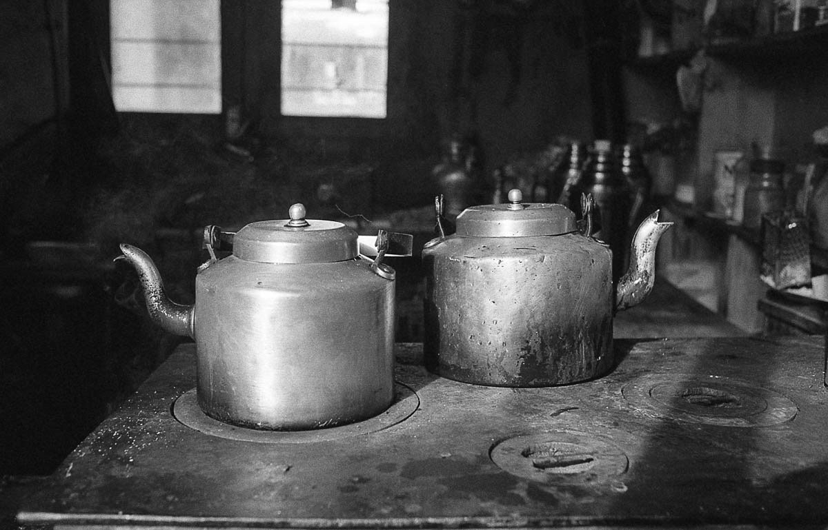 In the guesthouse kitchen, pots of tea patiently await the arrival of tourists.