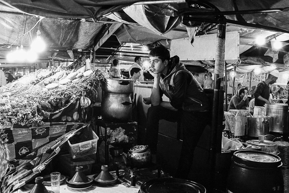 Waiter waits for customers in one of the many cafes that make up the famous Jemaa el-Fnaa square, biggest food-court in Marrakech. 