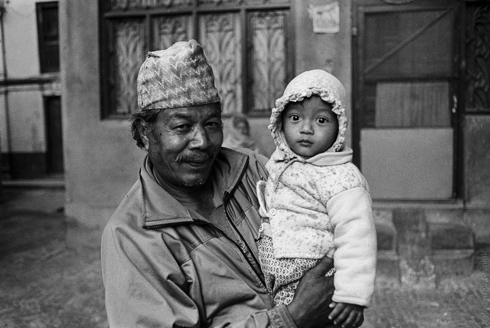 Capturing the spirit of Nepali hospitality: A grandfather and grandson pose for a photo with smiles, showing warmth and kindness of Nepali culture