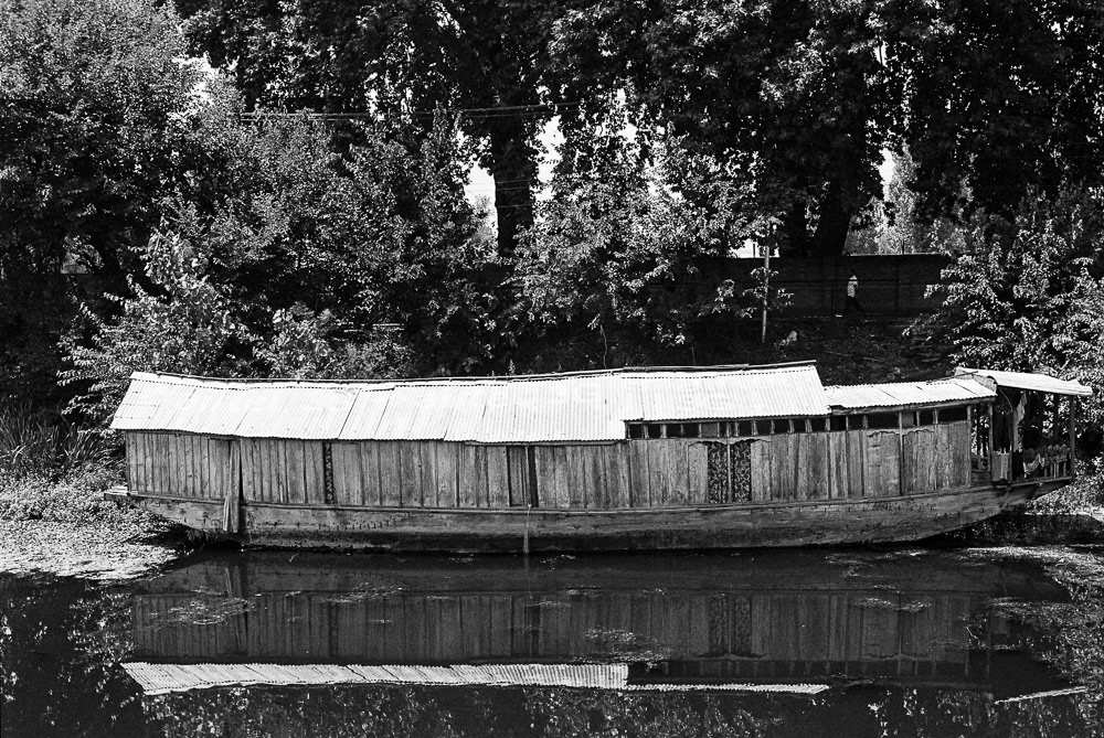 A houseboat is a cozy home where people live on the calm waters of Dal Lake.