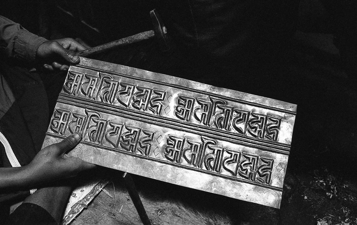 Mantras are inscribed on copper plates to create prayer drums.
