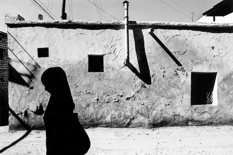 Capturing the essence of Bukhara's rich Islamic heritage - silhouette of a woman in traditional clothes against the ancient streets of this historic city.