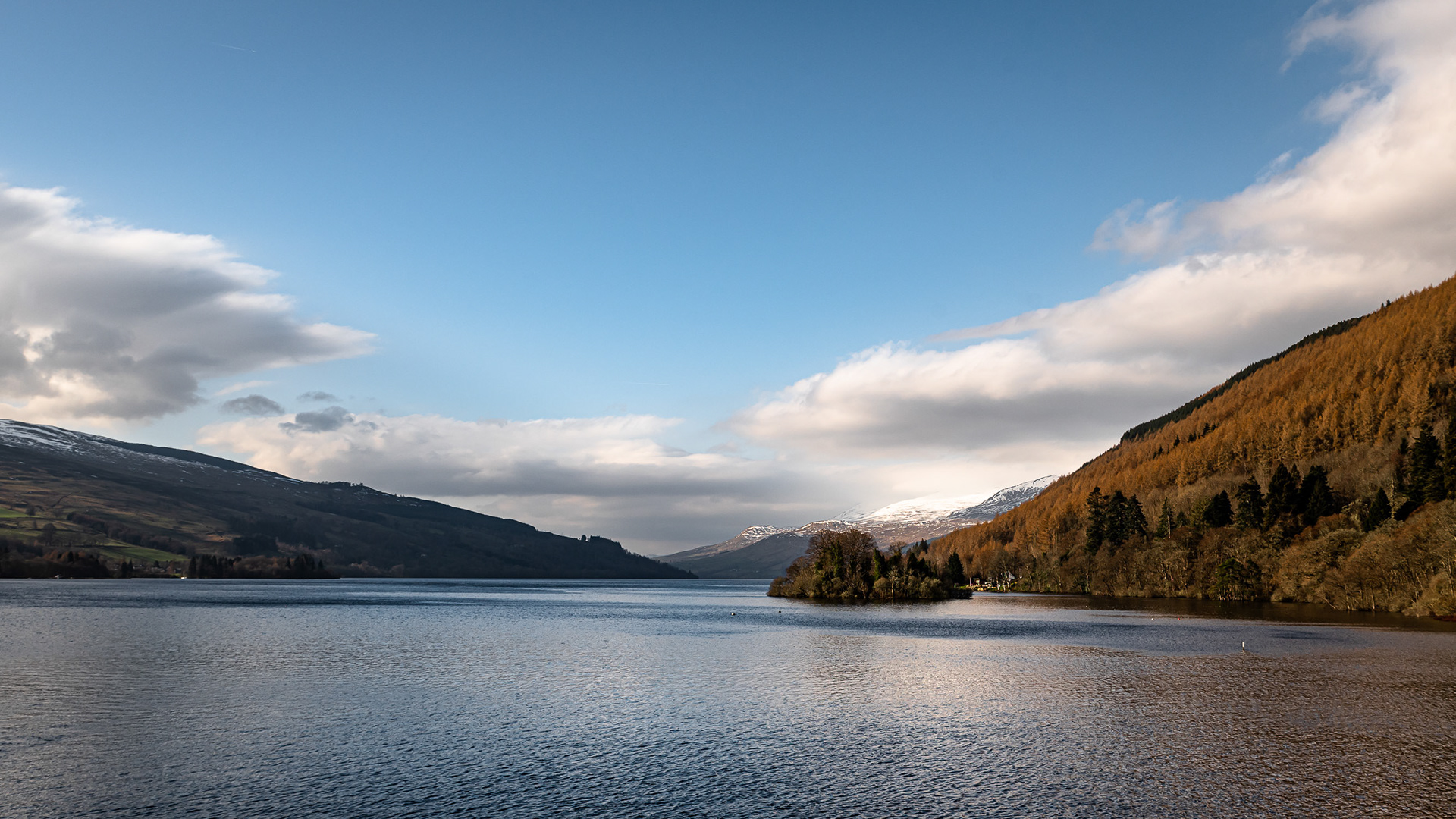 A clear sky above Loch Tay at Kenmore in Perthshire, Scotland, with a snow topped Ben Lawers in the distance