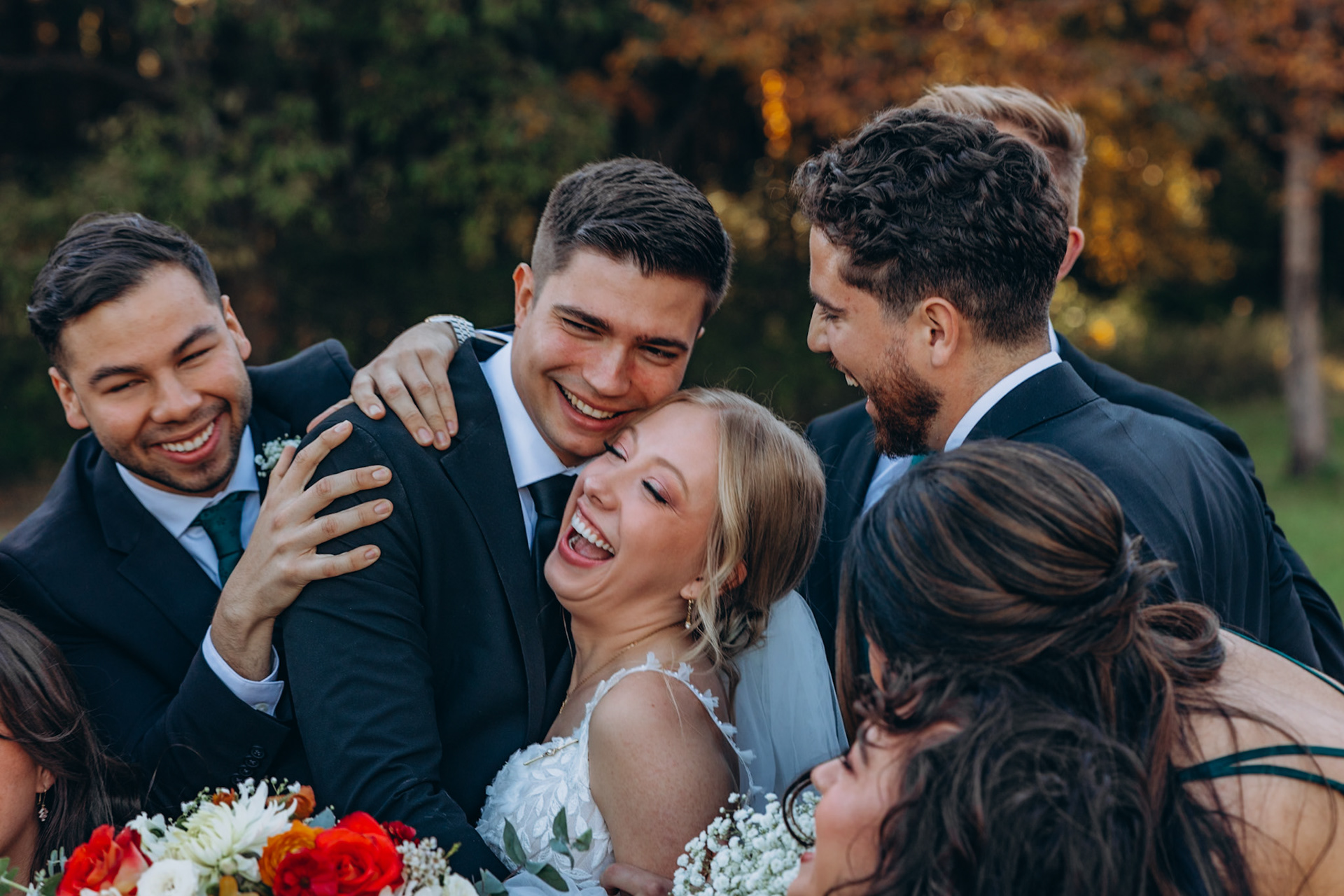 bridal party joyfully surrounds the newly weds
