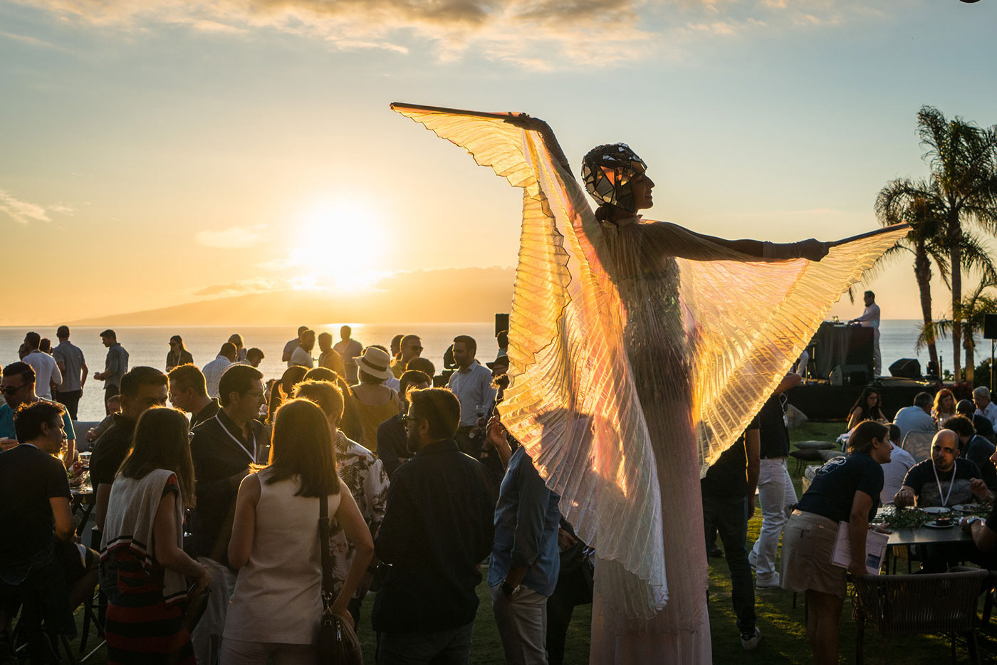 Outdoor corporate event in Tenerife at sunset with guests and an illuminated performer