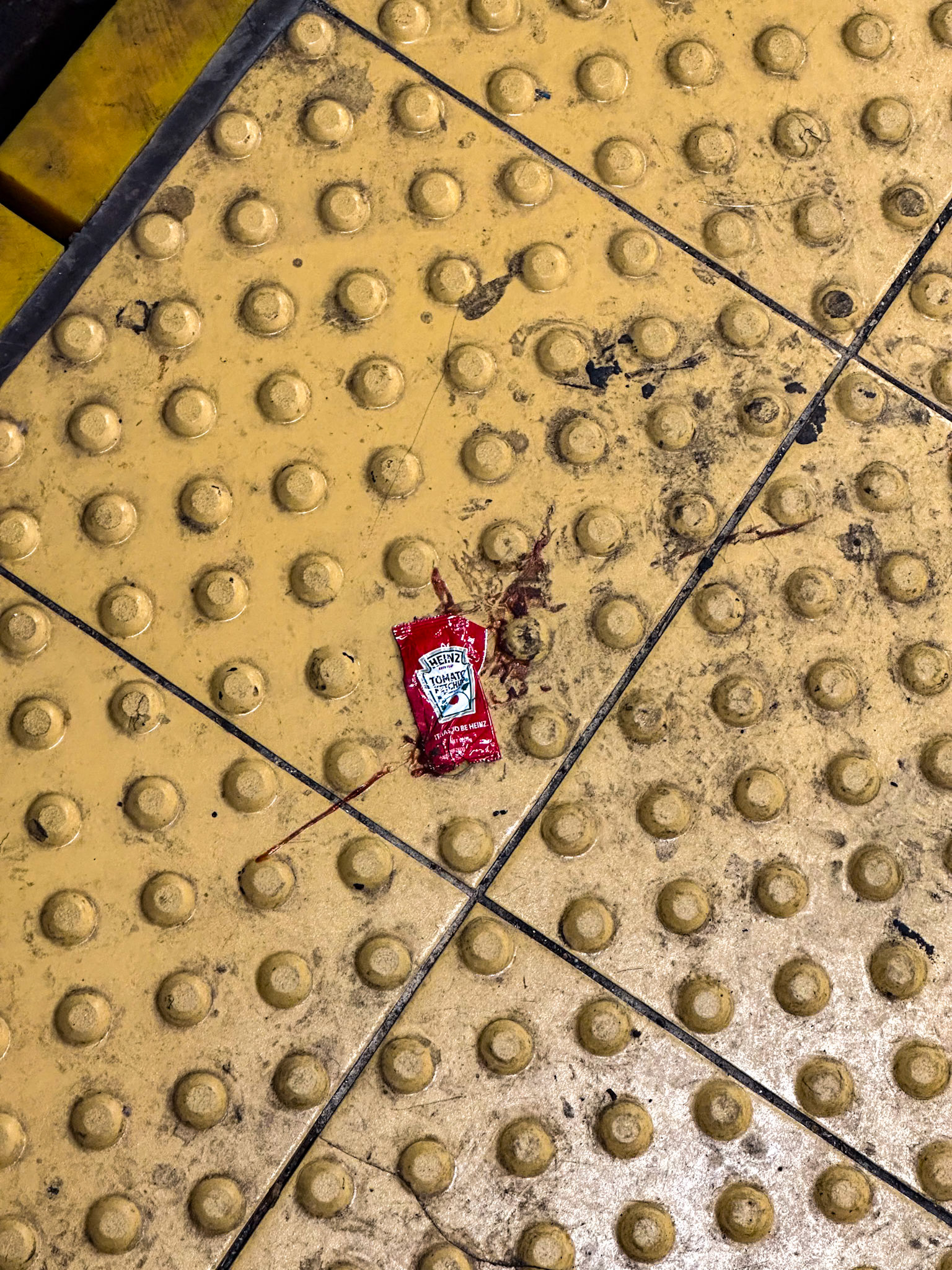 New York, NY, US - May 3, 2024: Burst ketchup packet on subway platform