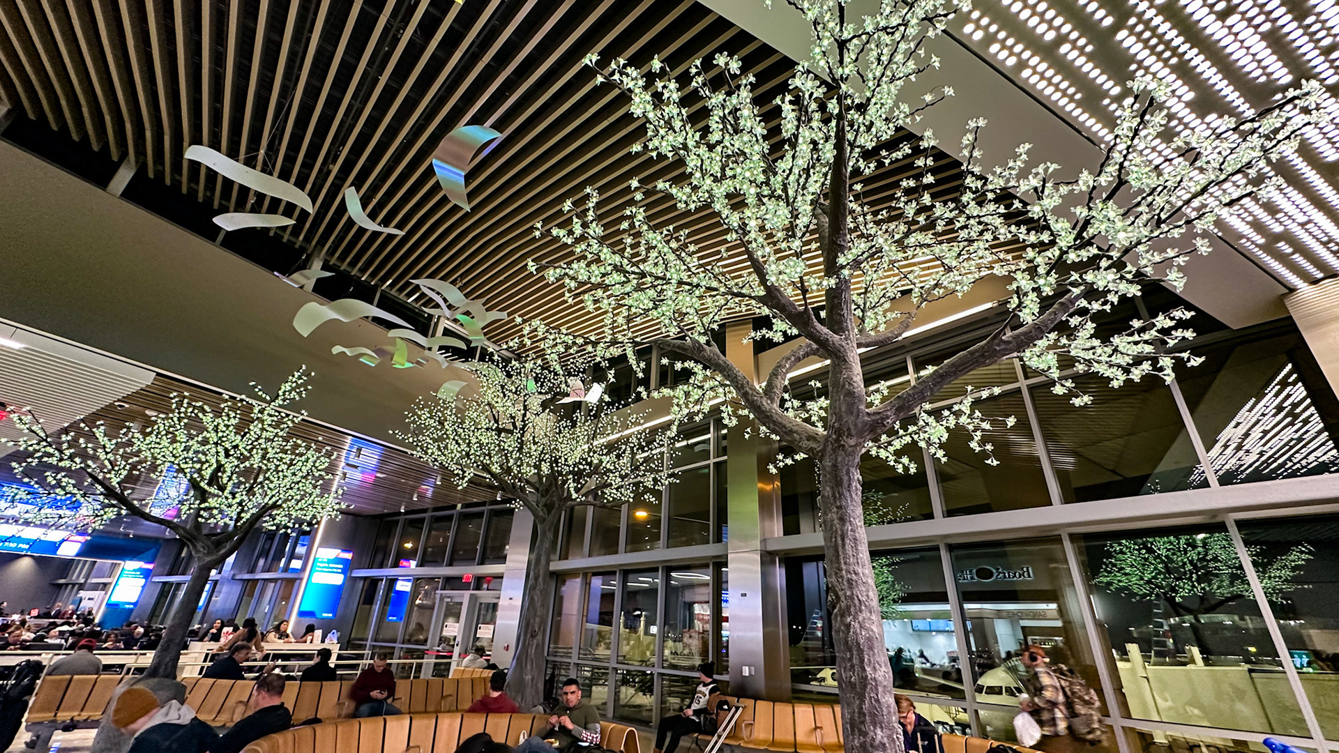 DFW Airport, TX, US - Feb 3, 2023: Decorative trees with flower blossom lights in food court