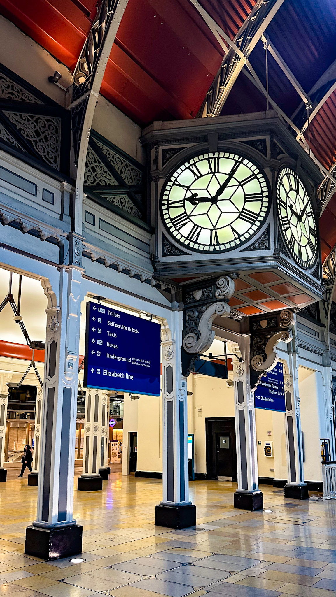 Paddington, London, UK - Apr 14, 2023: Clock and directional signs in Paddington Station