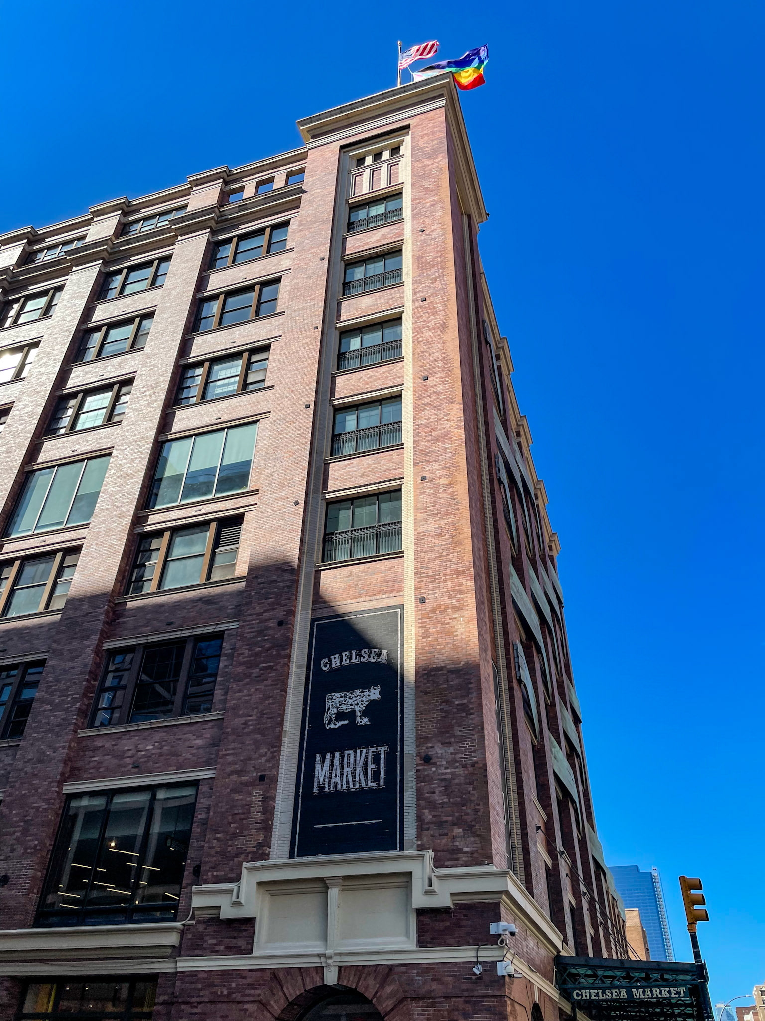 New York, NY - Jun 19, 2022: American flag and Pride flag flying above Chelsea Market
