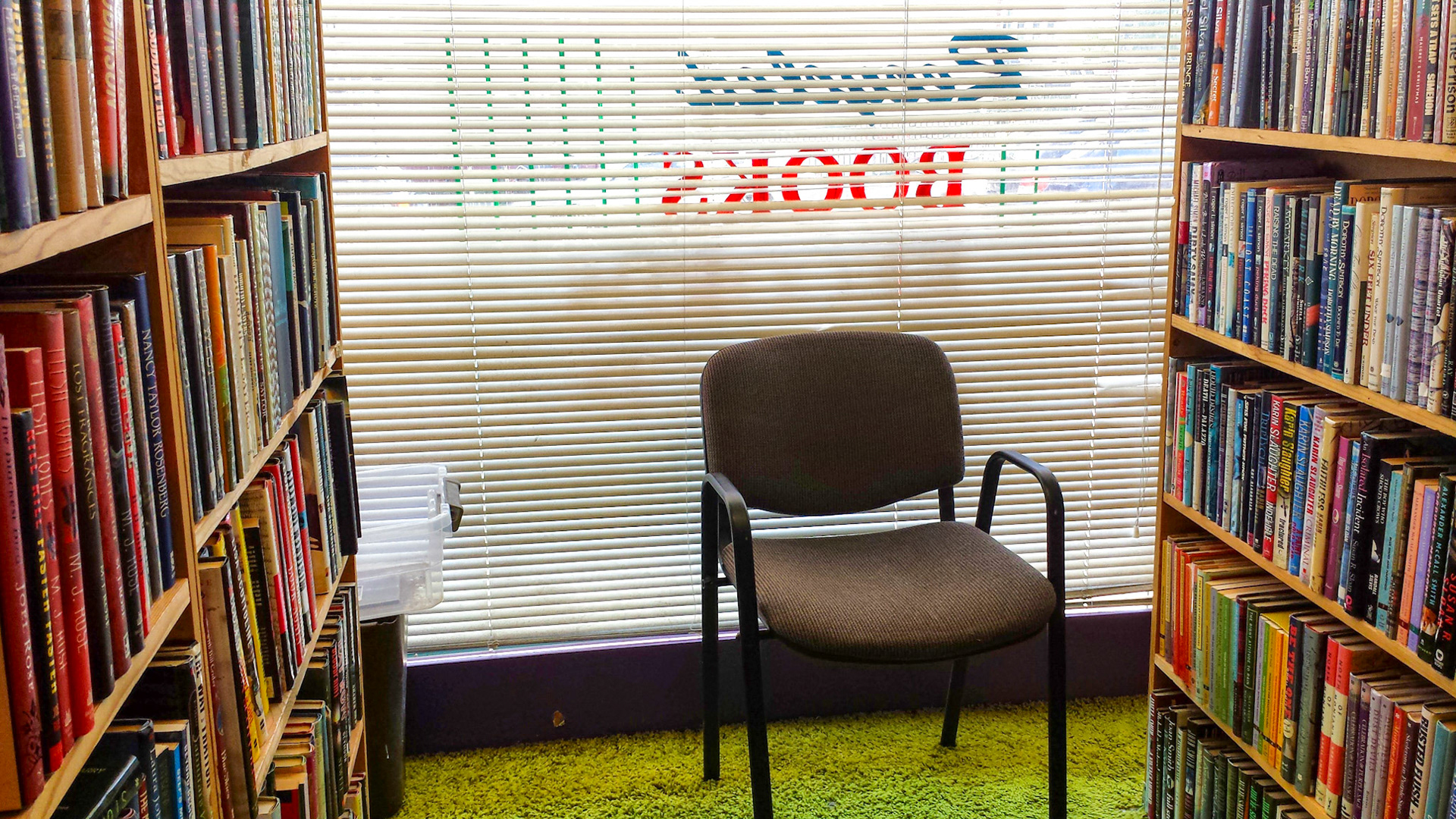 Denton, TX, US - Aug 31, 2014: Recycled Books interior shelves and chair against window