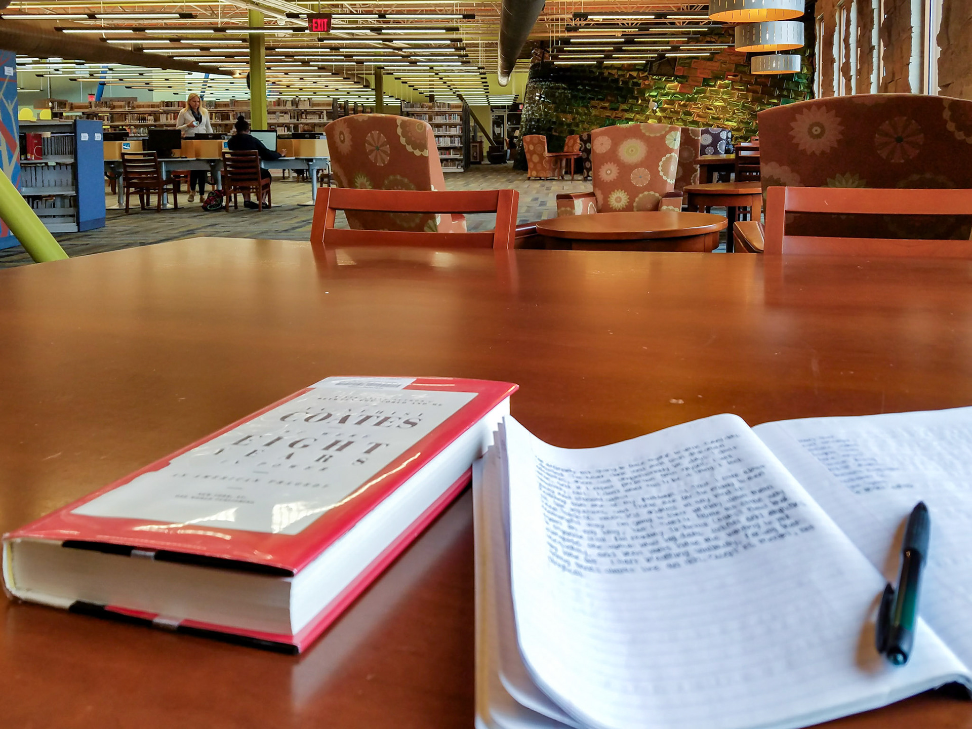 Wylie, TX, US - Dec 7, 2017: Hardcover book and open notebook with pen on public library table
