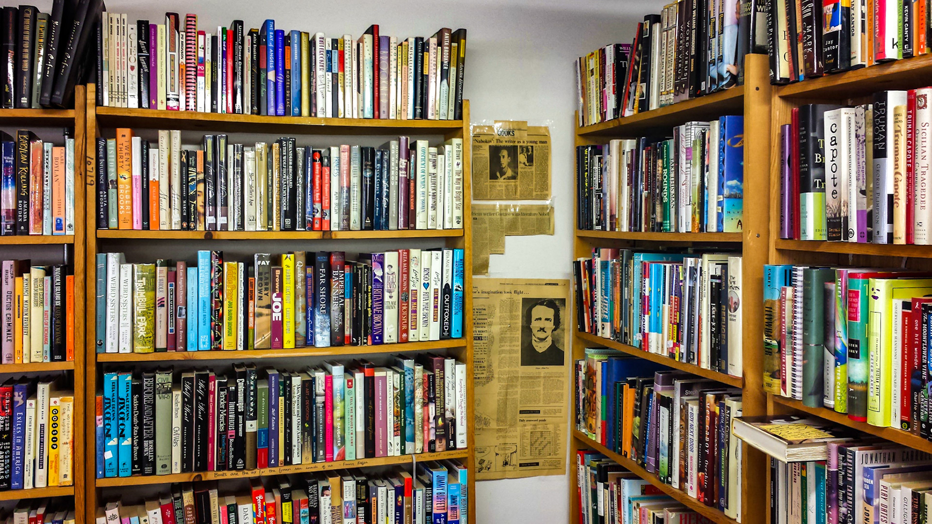 Denton, TX, US - Aug 31, 2014: Recycled Books interior, fiction shelves and old newspaper clippings featuring Edgar Allan Poe
