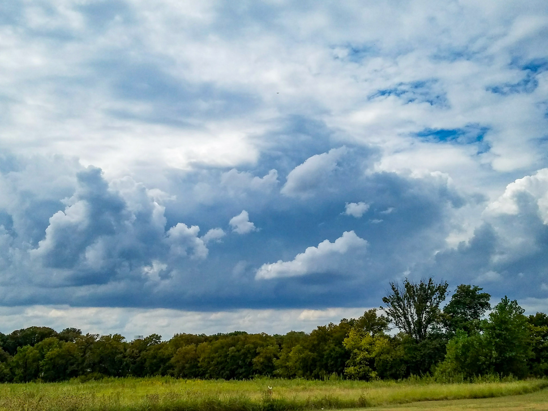 Wylie, TX, US - Sep 26, 2017: Thick clouds, trees, and a field