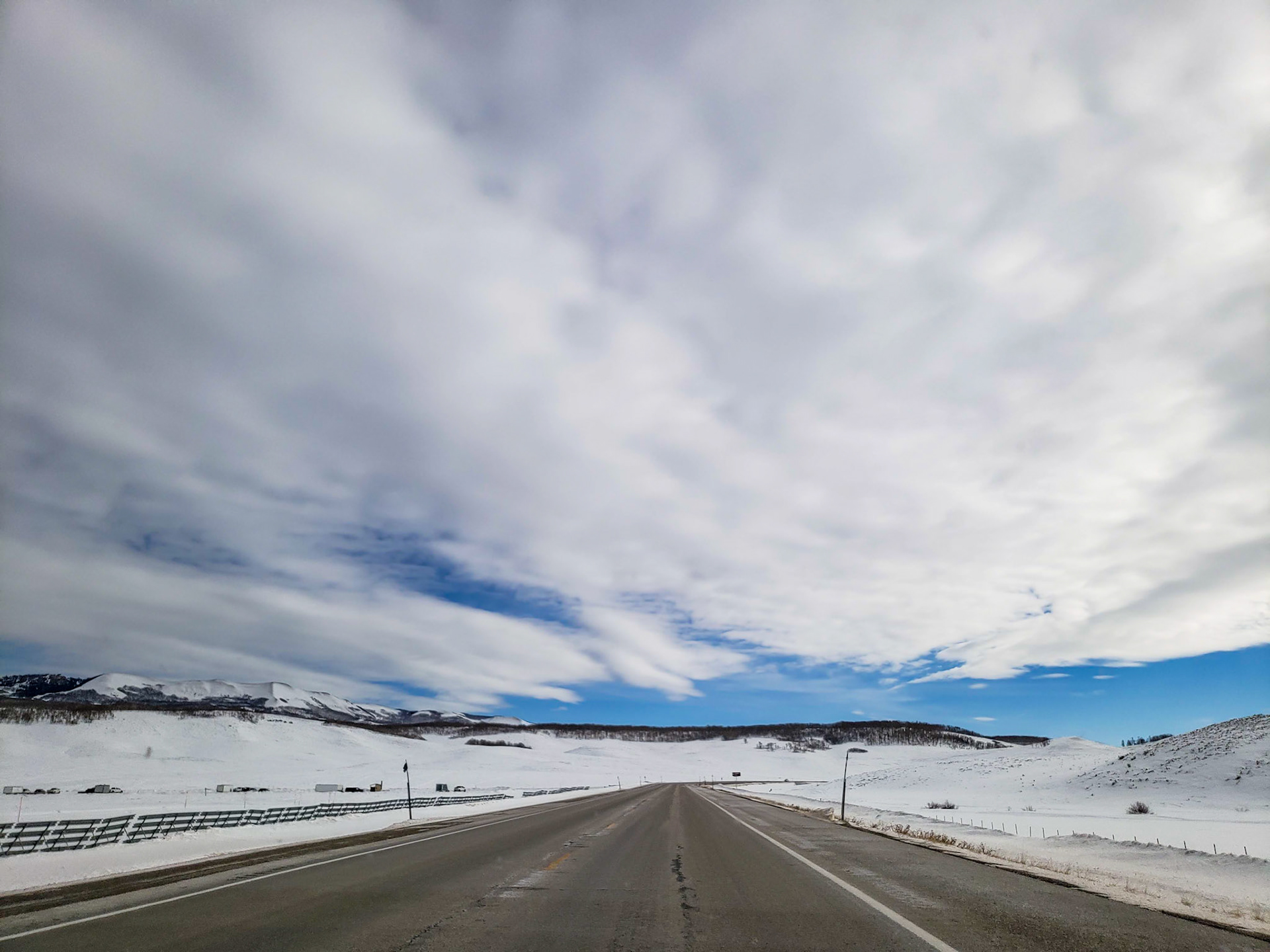 Uinta Basin, UT, US - Dec 23, 2018: Clear road with snowy landscape and thick cloud cover