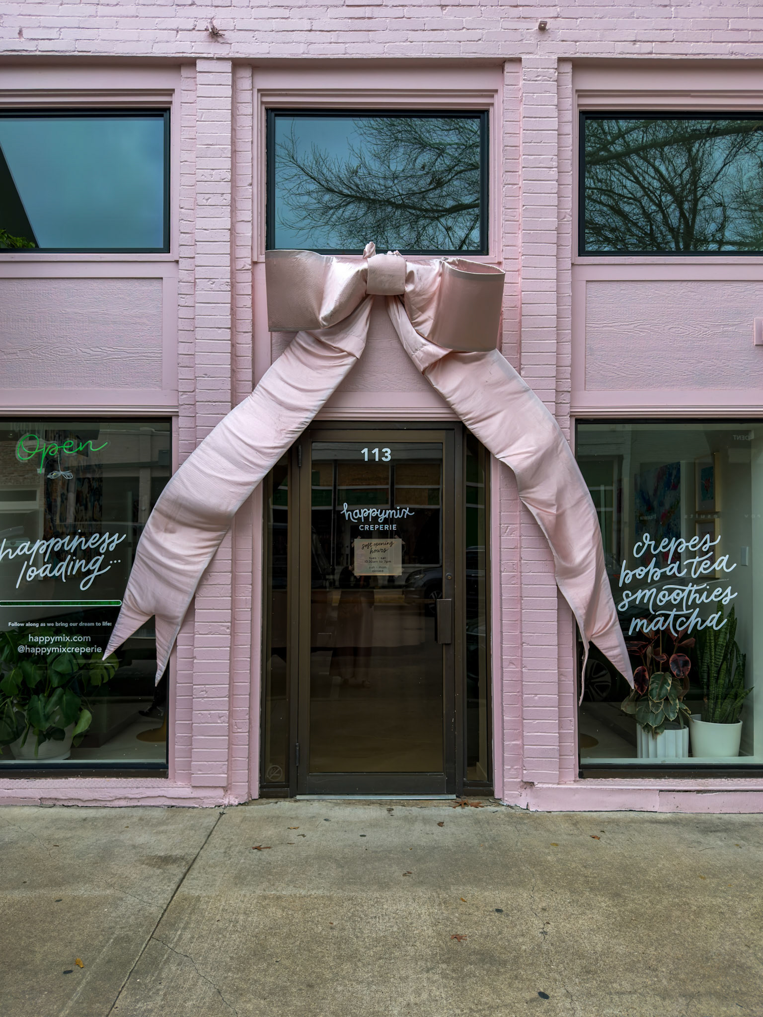McKinney, TX, US - Mar 1, 2026: Pink creperie entrance with giant bow over door