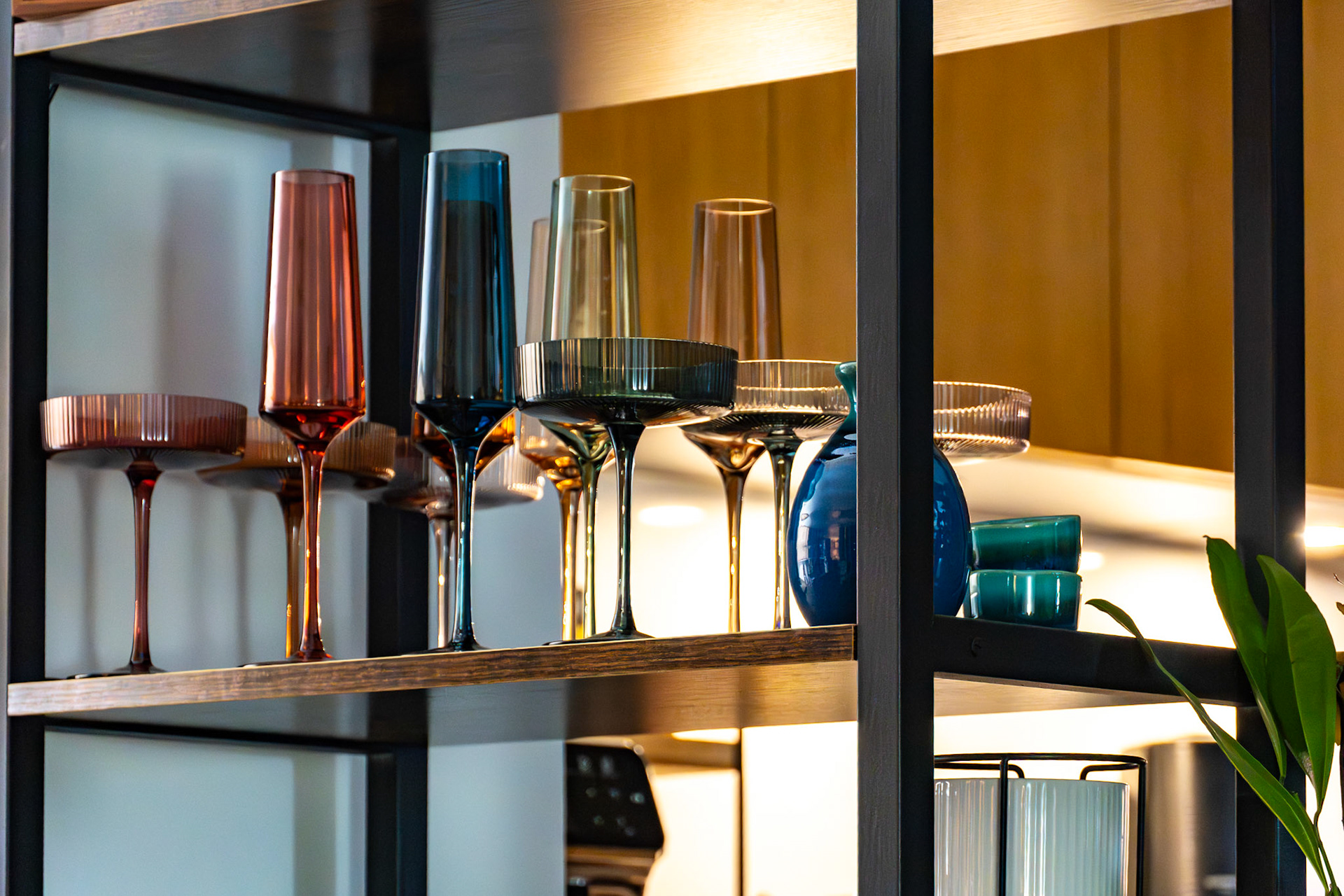 New York, NY, US - Oct 31, 2023: Colorful champagne flutes and coupe glasses on open shelf