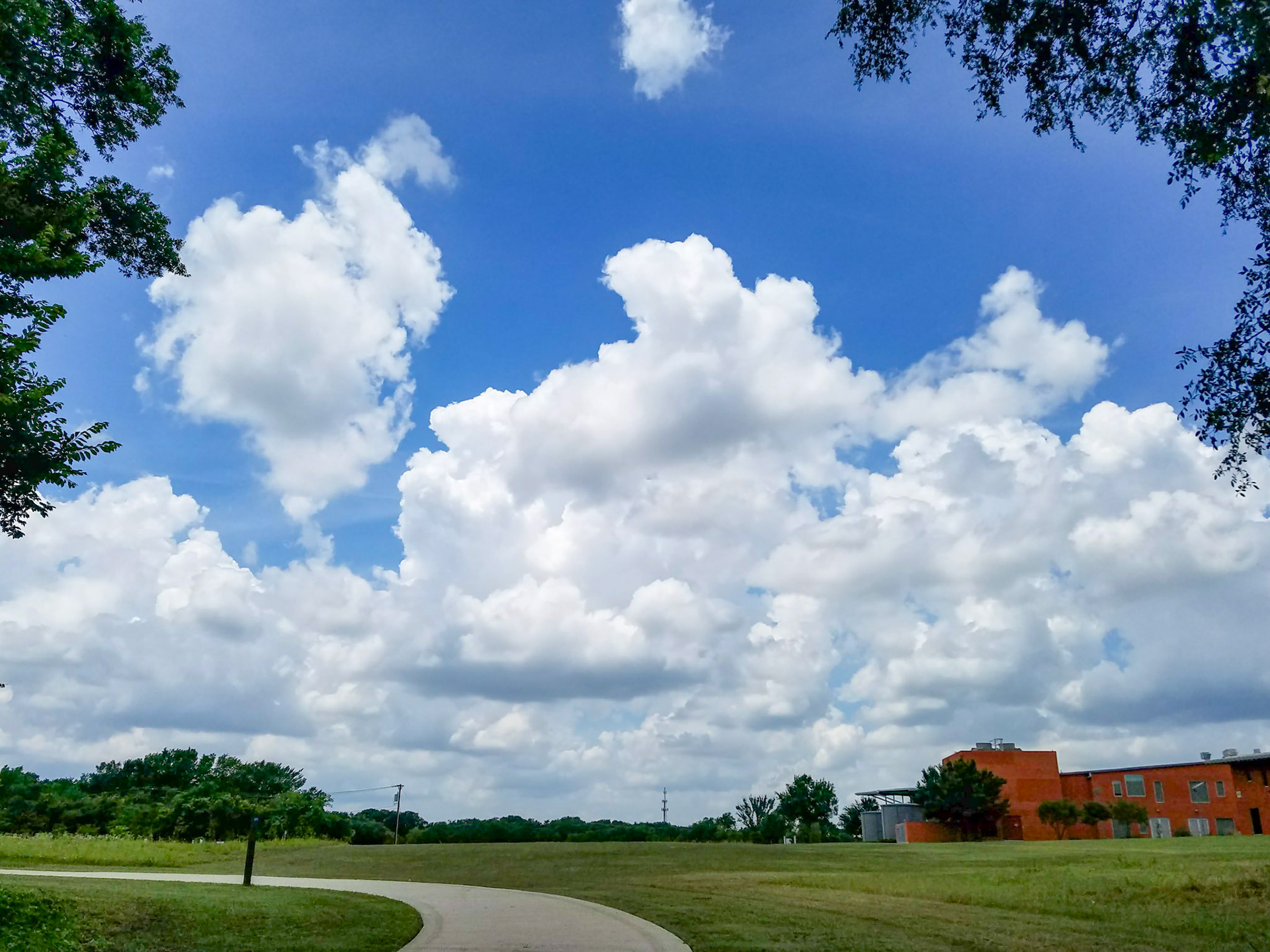Wylie, TX, US - May 22, 2018: Puffy clouds above municipal walking trail behind Smith Public Library