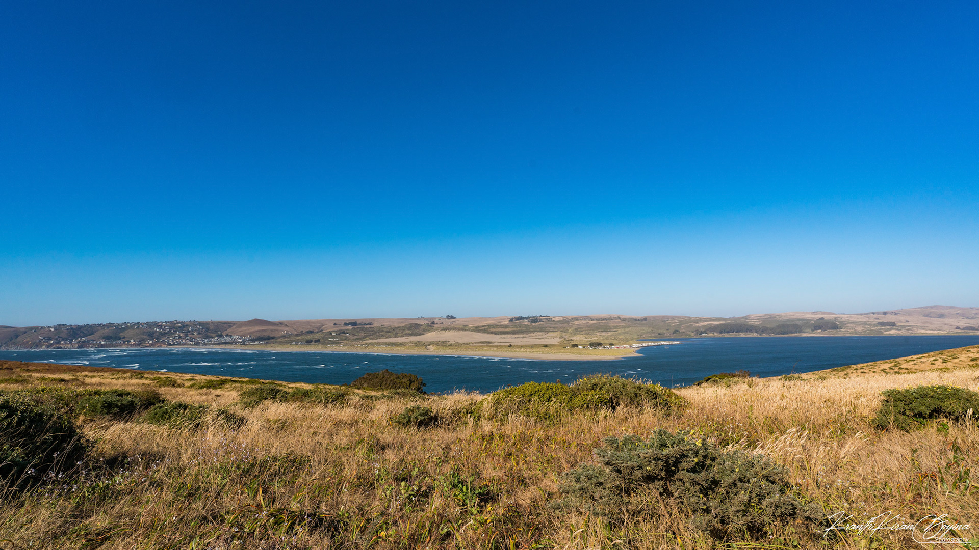 Dillon Beach is at the mouth of Tomales Bay. Here you can see waves crashing into Dillon beach on the left where the waters are still on the right in the Tomales Bay.
