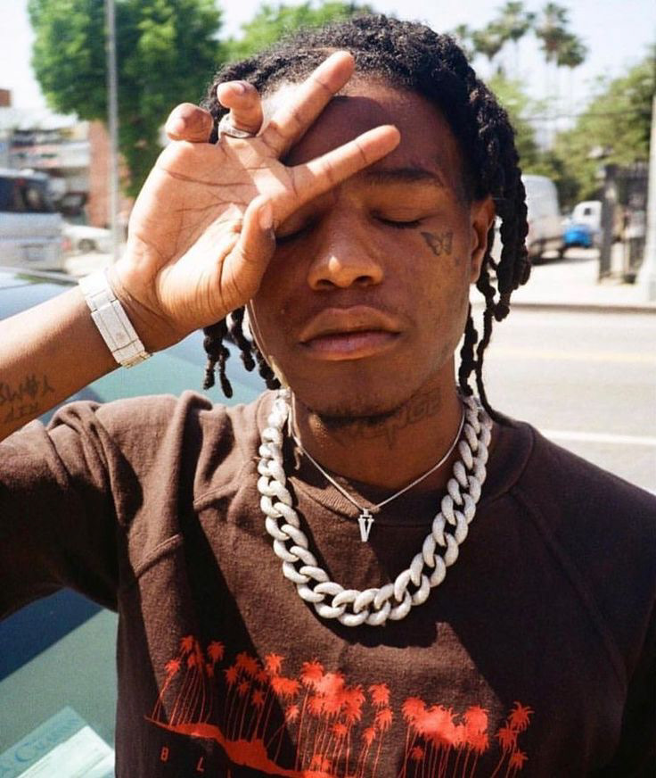 Ian Connor throwing up YVL wearing Vlone chain with sun hitting his hand and forehead.