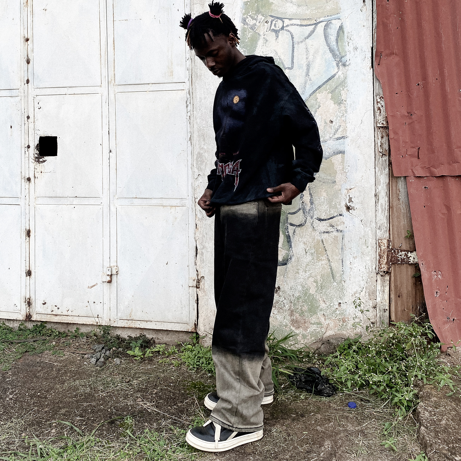 Bradlee Mwesigwa wearing black hoodie and faded jeans, holding iPhone 5c, WPBP film behind-the-scenes
