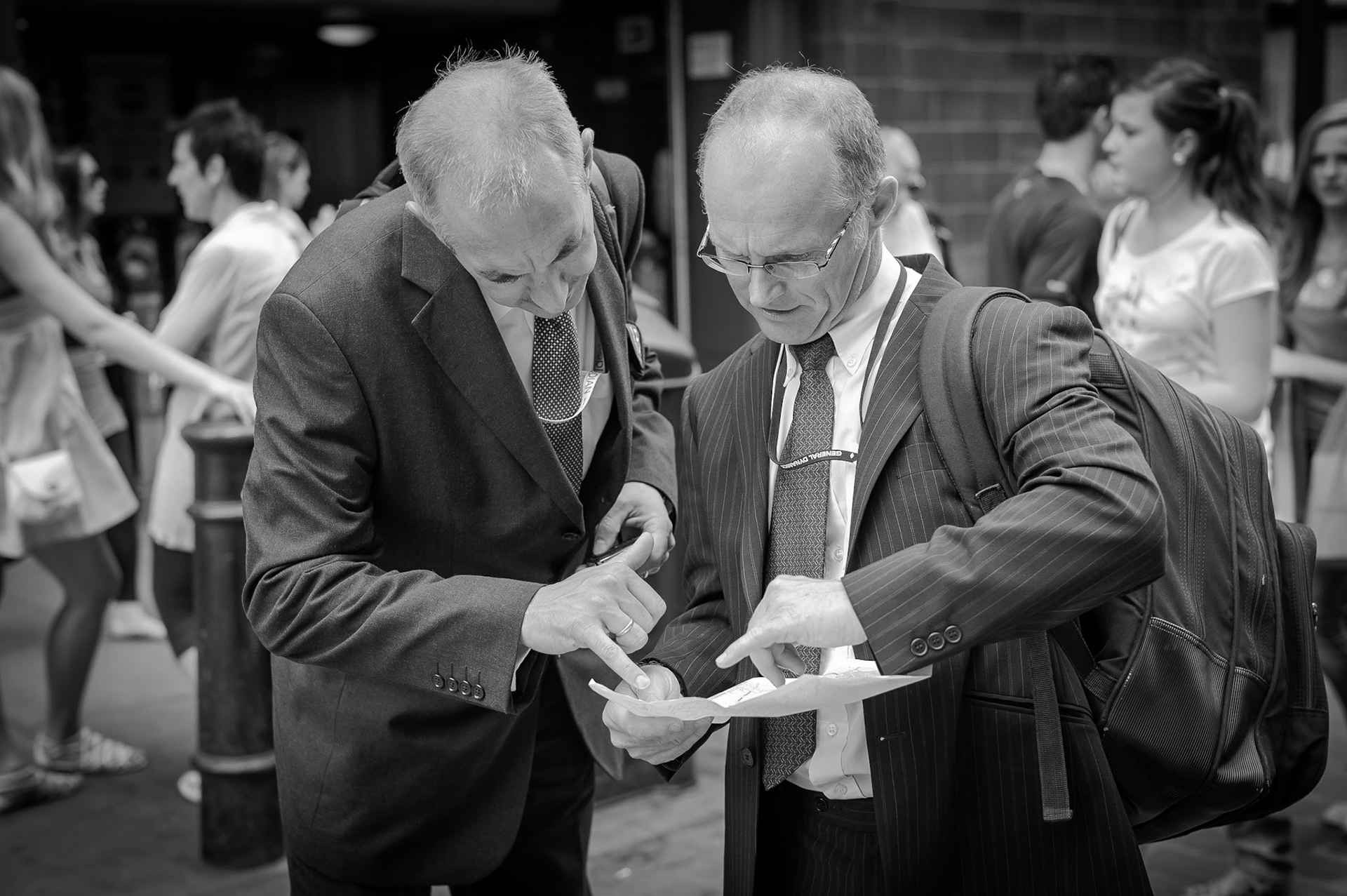 Two businessman check thier directions by consulting a map in London's Covent Garden