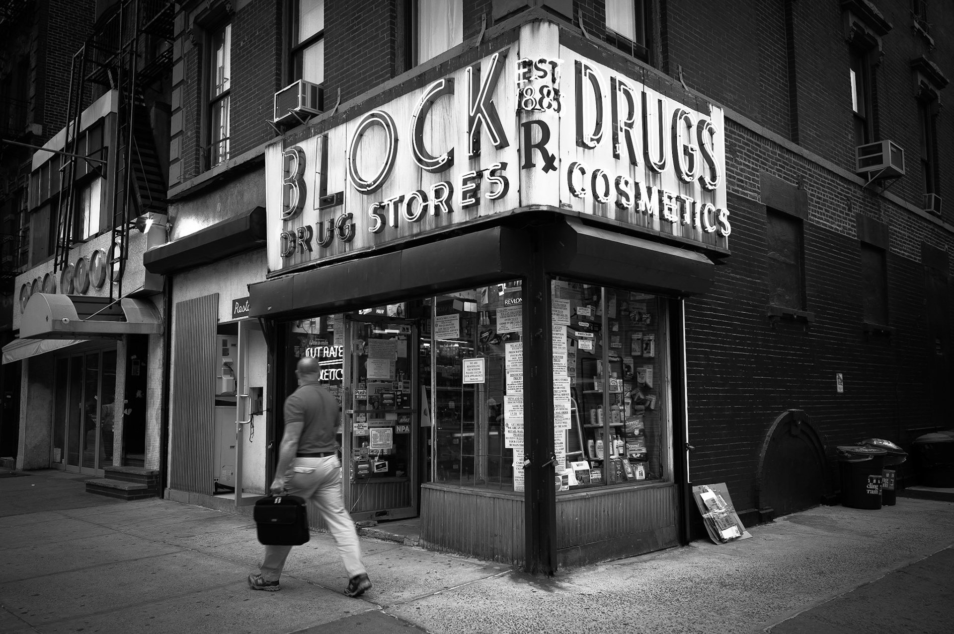 Man strides past a drug store in New York's Lower East Side.