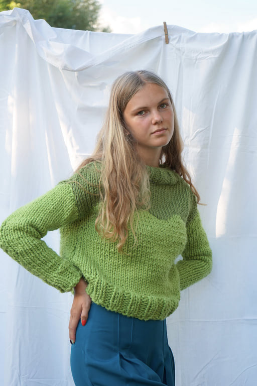 Knitted sweater in green tones and blue pleated high-waist trousers
