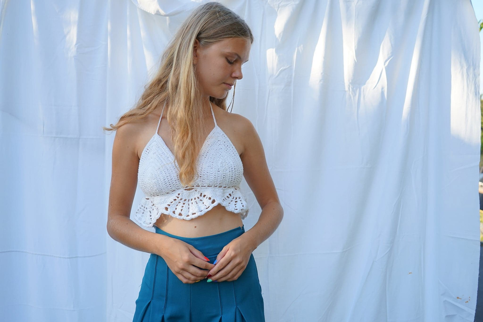 Crochet top and blue pleated high-waist trousers