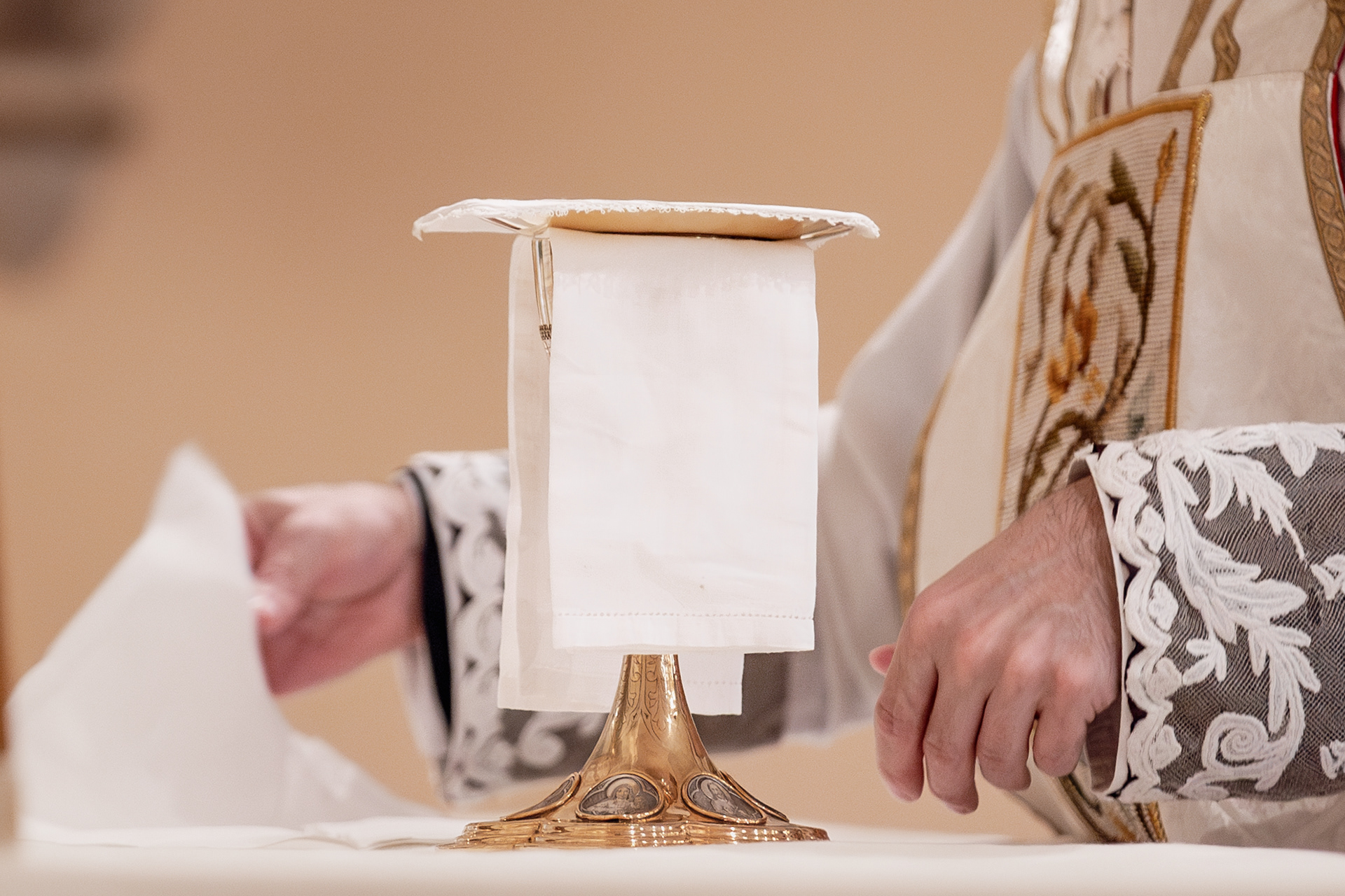 Bottom to top: Chalice, purificator, paten, pall. These will be covered with the chalice veil. The burse will be placed on top.