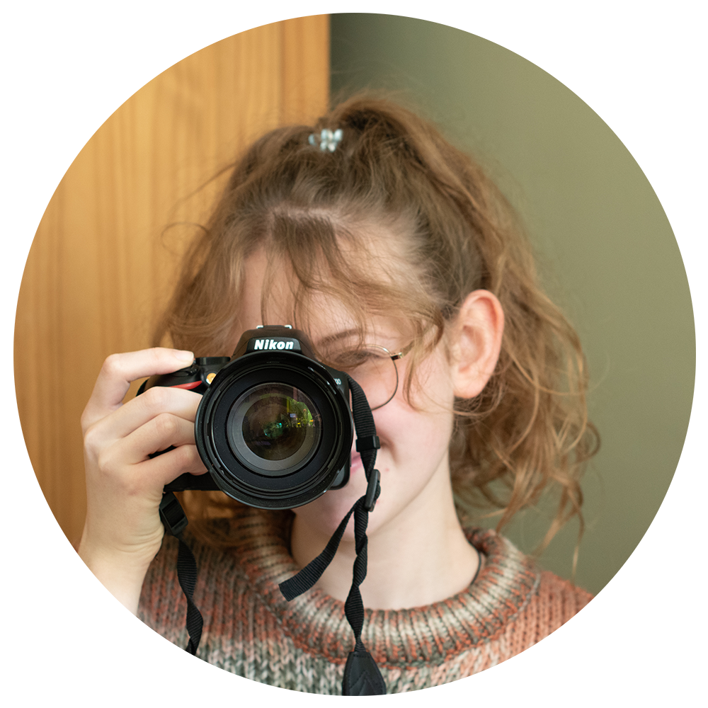 Photographer Amy Foster holding camera up smiling