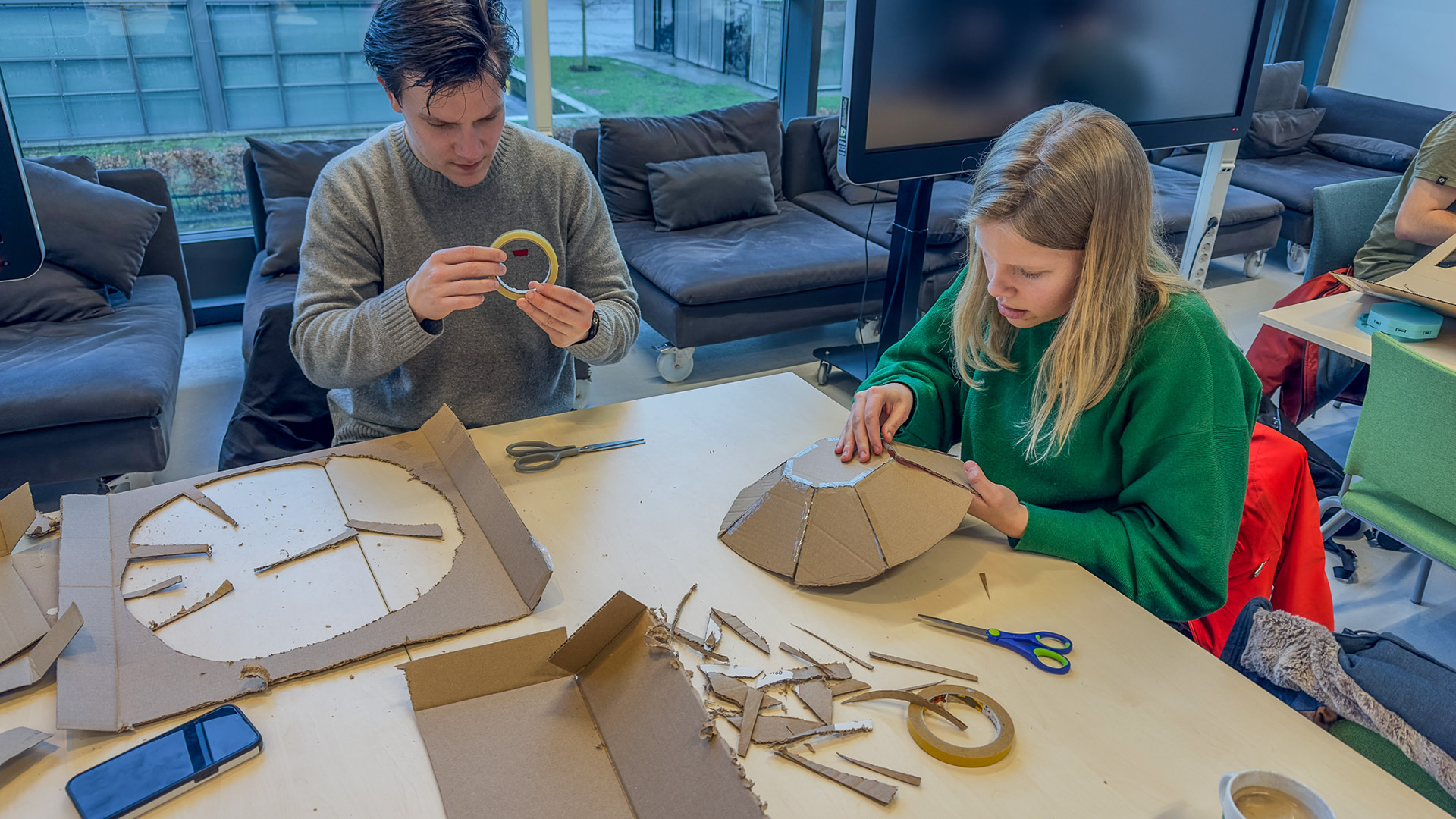 Figure 4. Using the available materials to stick together the cut out cardboard.