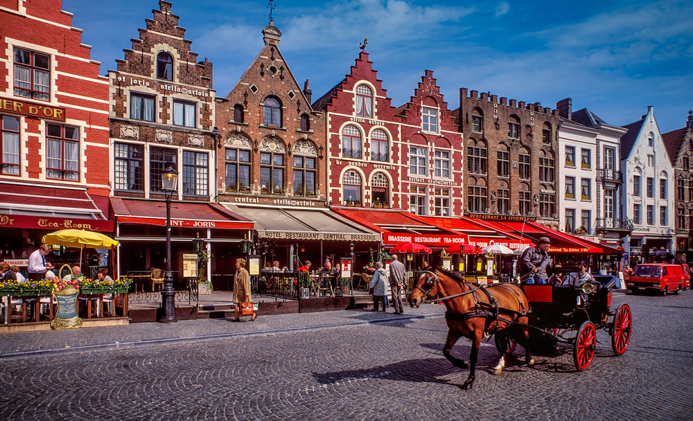 #2500 A Horse Drawn Carriage Passing the Historic Buildings on the Market Square in Old Town Bruges