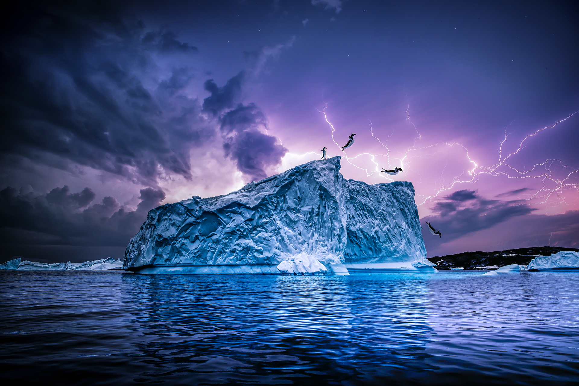 Penguins jumping off of an iceburg during a thunderstorm in antartica
