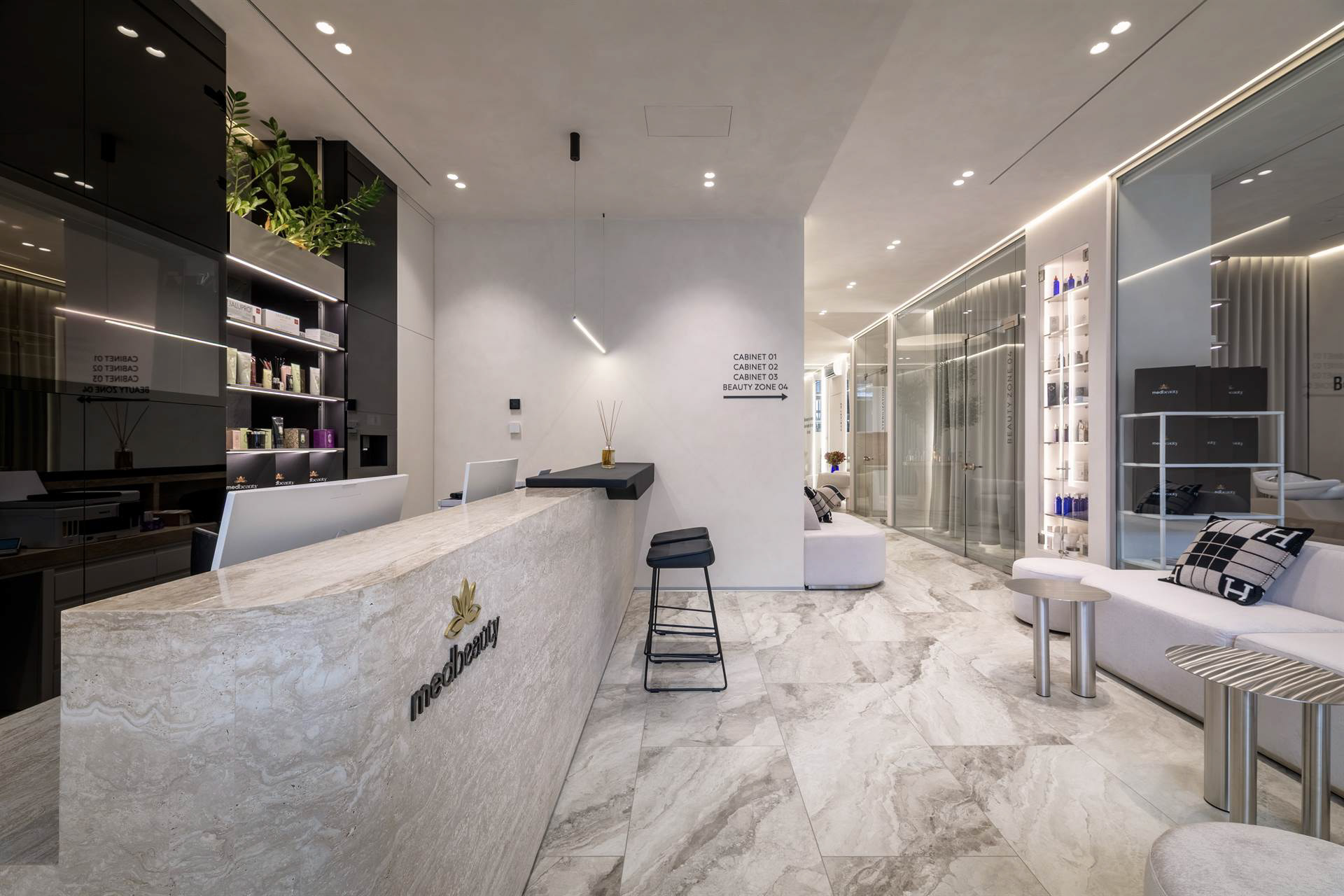 Бічний вигляд рецепції б’юті клініки зі світлою стійкою та мінімалістичним дизайном