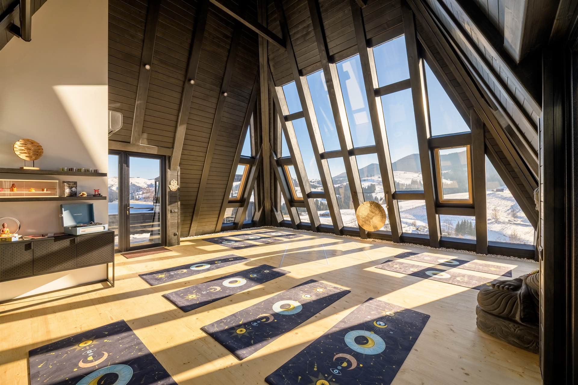 Загальний денний вигляд пірамідального залу із розкладеними килимками для йоги під природним світлом