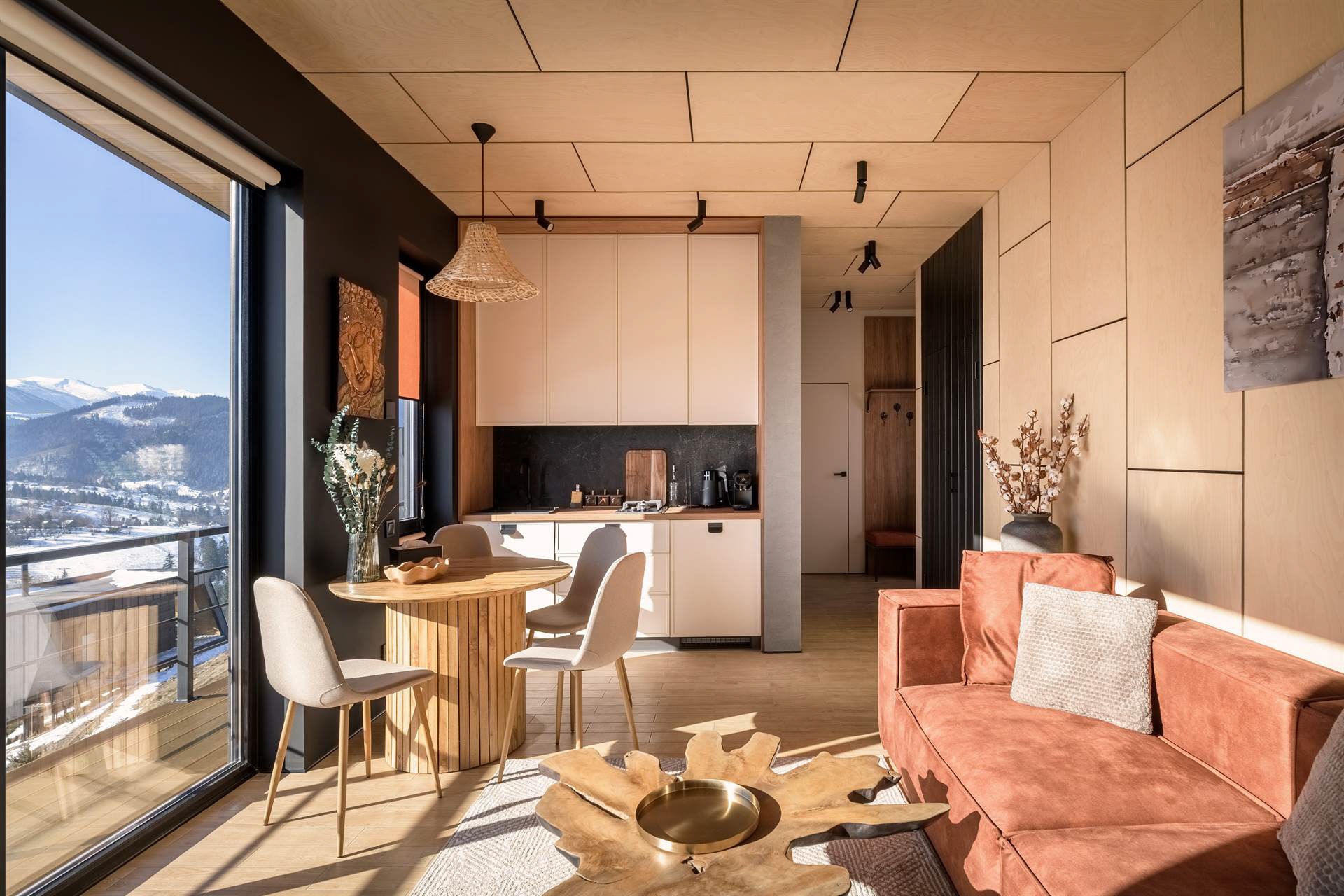 Зона відпочинку з м’якими диванами, балійським декором та теплими текстурами дерева