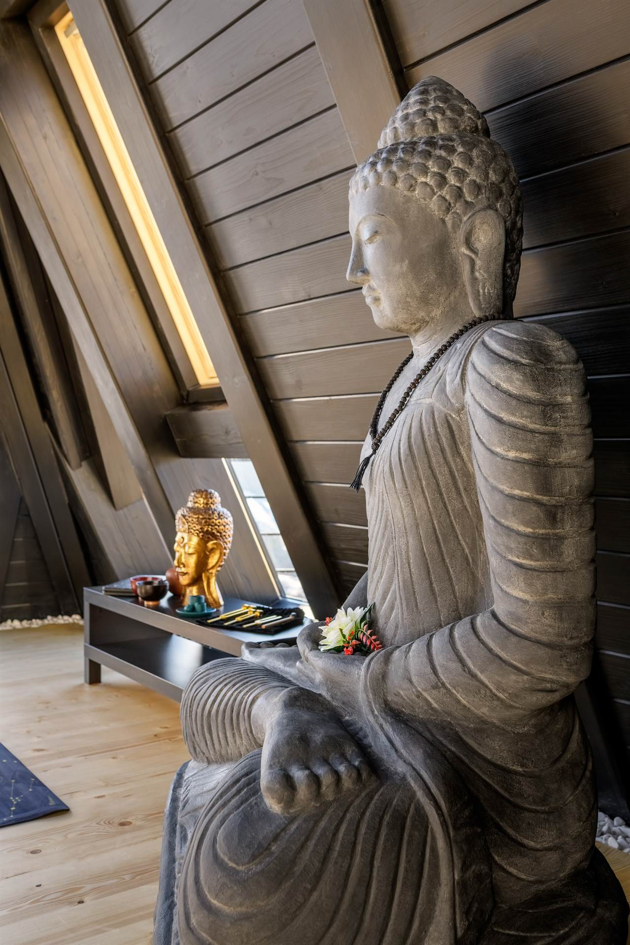 Статуя Будди в загальному просторі на тлі дерев’яних стін