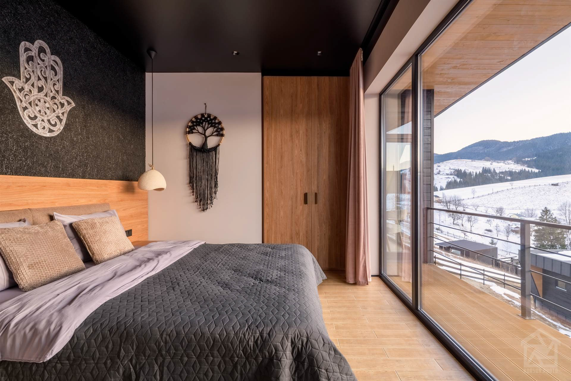 Ліжко біля великого скління з природним світлом і мінімалістичним декором