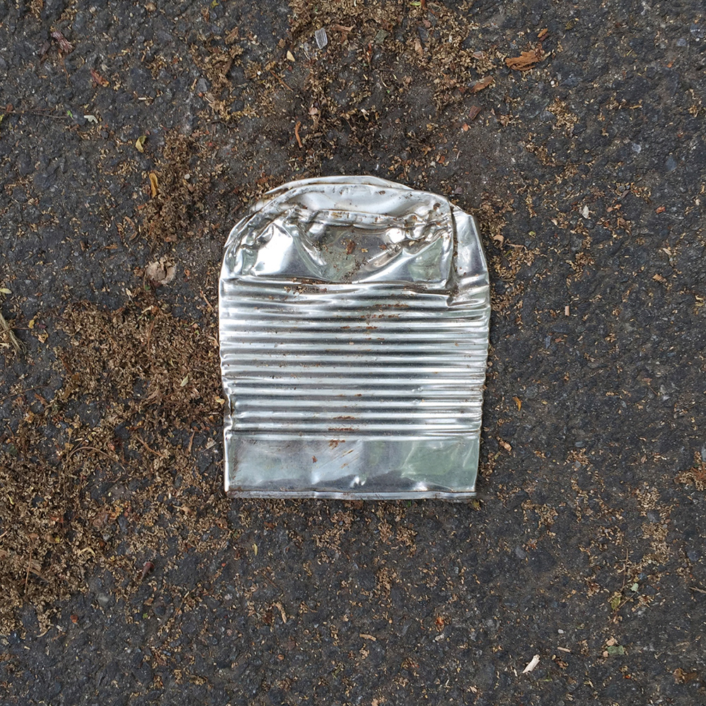 A photo of lost or discarded material found on a city street—with a form interpreted as resembling a pencil ferrule.