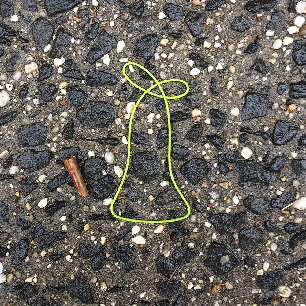 A photo of lost or discarded material found on a city street—with a form interpreted as resembling a bell.