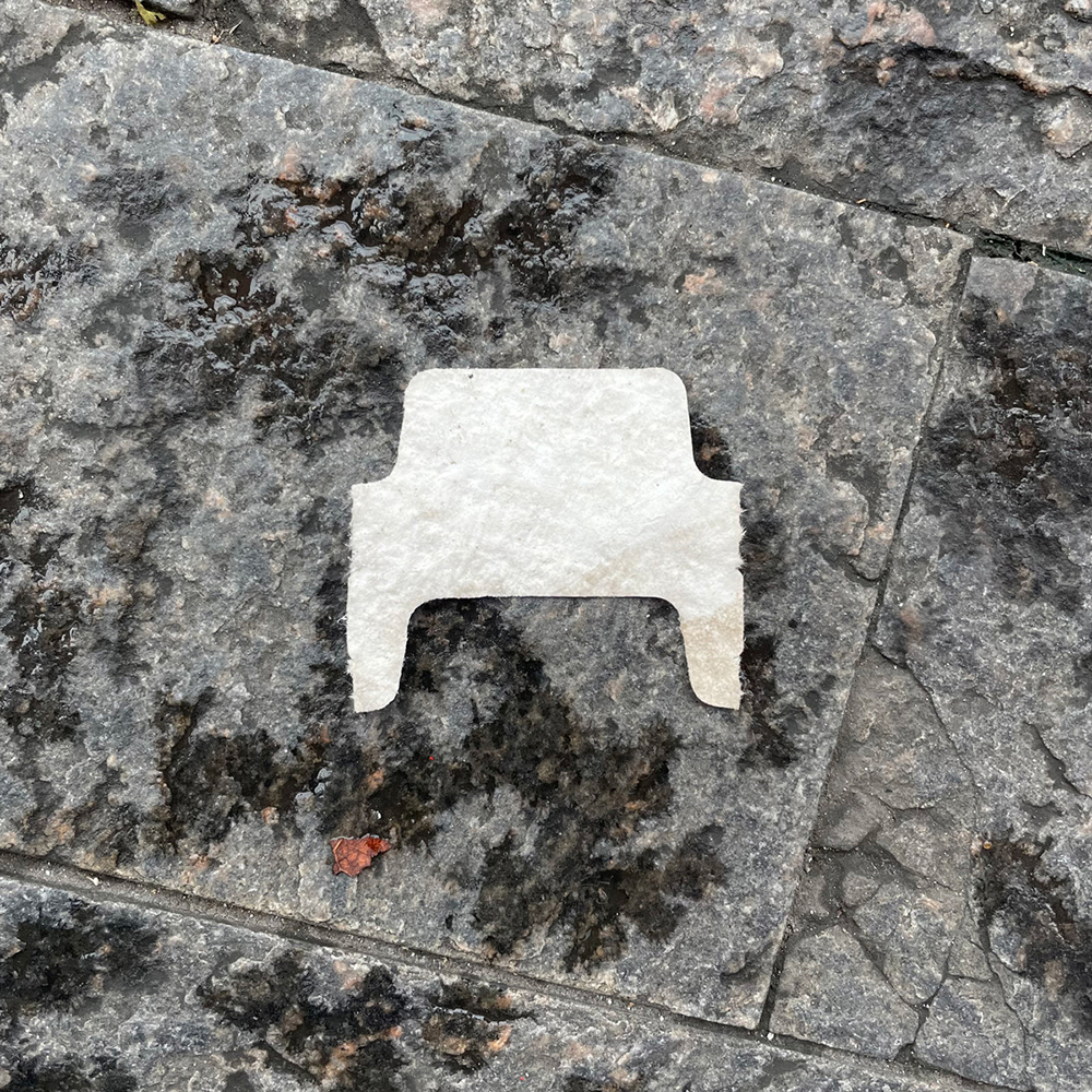 A photo of lost or discarded material found on a city street—with a form interpreted as resembling a chair.